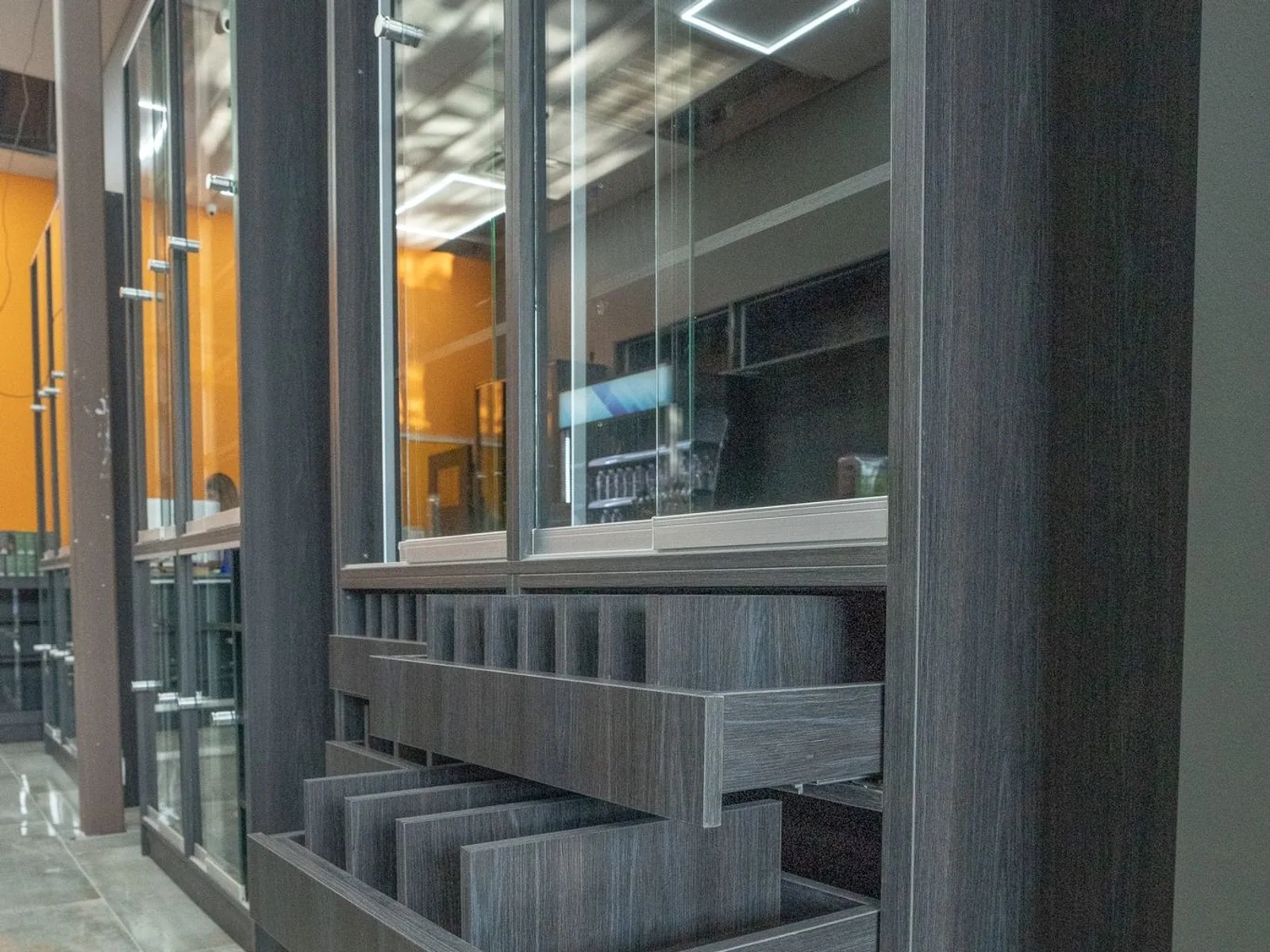 Dark wood retail display cabinet with glass showcases and open storage drawers