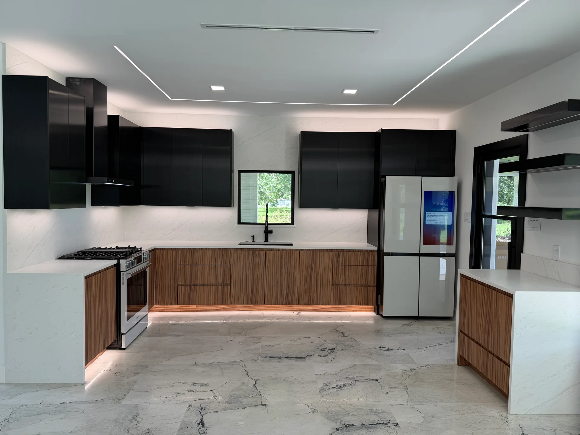 Modern kitchen with black upper cabinets, walnut base cabinets, and integrated lighting